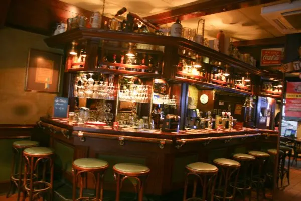 Le bar illuminé et ses tabourets