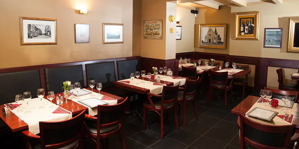 Salle avec tables en bois et photos encadrées